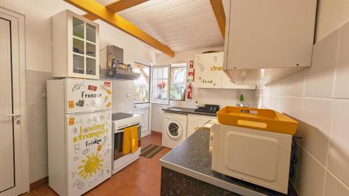 a kitchen with a refrigerator and a stove at Loving Strangers Hostel in Madalena