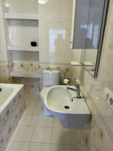 a white bathroom with a sink and a toilet at Отдых у моря Одесса in Kryzhanivka