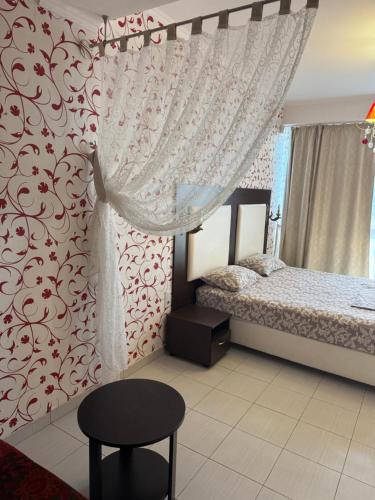a bedroom with a bed with a curtain and a stool at Отдых у моря Одесса in Kryzhanivka
