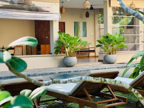 a patio with a table and chairs and plants at Peacock Villa in Mirissa