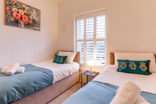 two beds in a room with a window at Hertfordshire's Luxury House in Hemel Hempstead