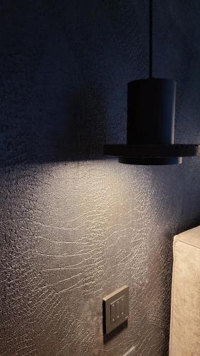 a black wall with a light switch and a lamp at La Torre sulla via Francigena in Gambassi Terme