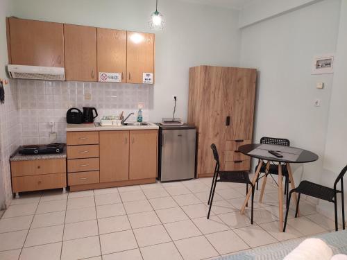 a kitchen with a table and a table and chairs at Kiki's cosy apartments in Nea Chili