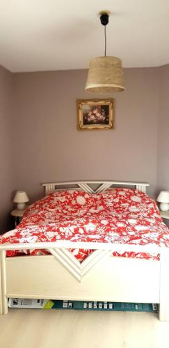 une chambre avec un lit avec une couverture rouge dans l'établissement Residence grand voile avec vue bassin, à Arcachon