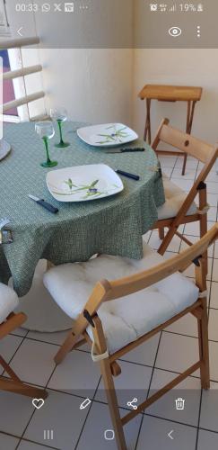 - une table à manger avec une table et des chaises vertes dans l'établissement Residence grand voile avec vue bassin, à Arcachon