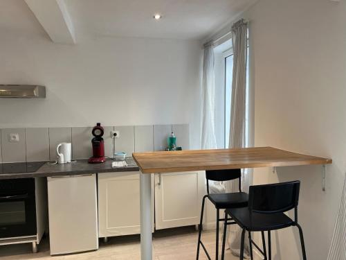 a kitchen with a table and two black chairs at Zen Studio Center Toulon in Toulon