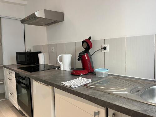 a kitchen with a red appliance on a counter at Zen Studio Center Toulon in Toulon