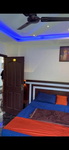 a bedroom with a bed with blue lights on the ceiling at HN cottages, Munnar in Jāmb