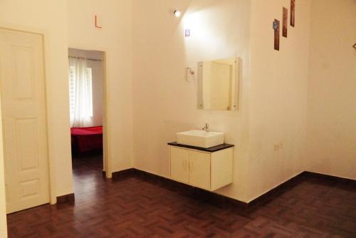 a bathroom with a sink and a mirror on a wall at Wilderstay Resort in Meppādi