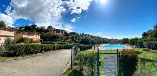 une clôture en face d'une cour avec une piscine dans l'établissement Les Oiseaux de Porticcio, à Grosseto-Prugna
