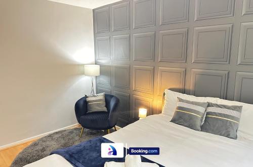 a bedroom with a bed and a chair at Spacious 3 BDR By Avalora Short Lets & Serviced Accommodation Queensway With Big Garden, Near Train Station, Airport & Large Driveway in Baguley
