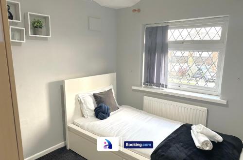 a small bedroom with a bed and a window at Spacious 3 BDR By Avalora Short Lets & Serviced Accommodation Queensway With Big Garden, Near Train Station, Airport & Large Driveway in Baguley