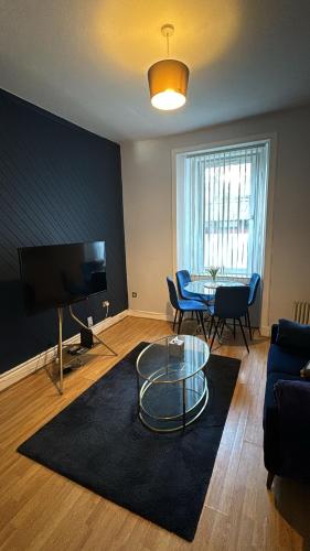 a living room with a glass table and a couch at Homely in Hampden in Glasgow