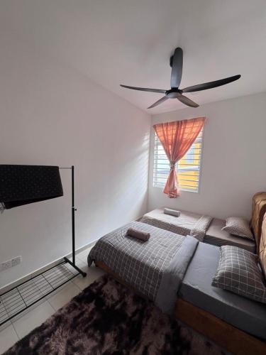 a bedroom with a bed and a ceiling fan at Qmal Homestay in Kampong Jelatang