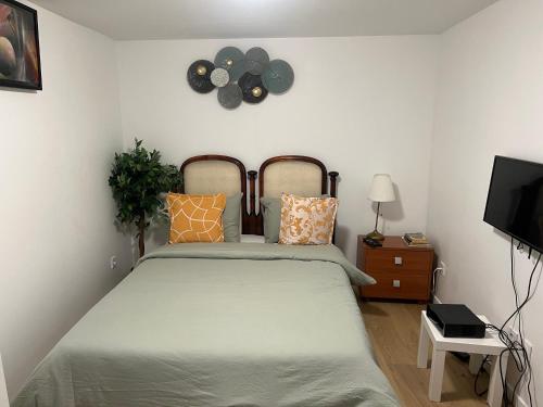 une chambre avec un lit et une horloge au mur dans l'établissement Île des Caraïbes, à Paris