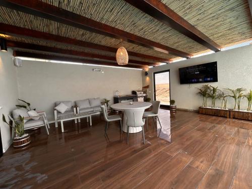 ein Esszimmer mit Tisch und Stühlen und einem Fernseher in der Unterkunft פנינה במדבר בערד in Arad