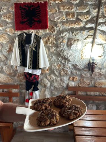 a plate of cookies on a table next to a mannequin at Kantina & Ferma Dukat in Vlorë