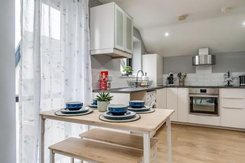 a kitchen with a table with blue dishes on it at City Line Apartment 5 in Carnmoney