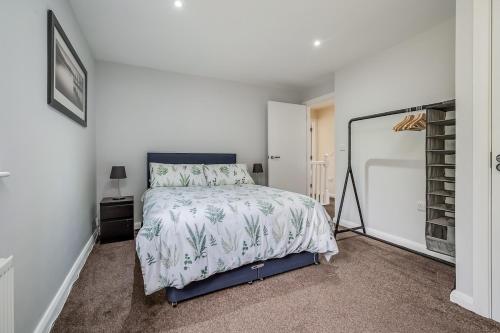 a bedroom with a bed and a white wall at City Line Apartment 5 in Carnmoney