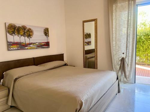 a bedroom with a bed and a mirror at Villa Costa del Sole - Capitolo in Monopoli