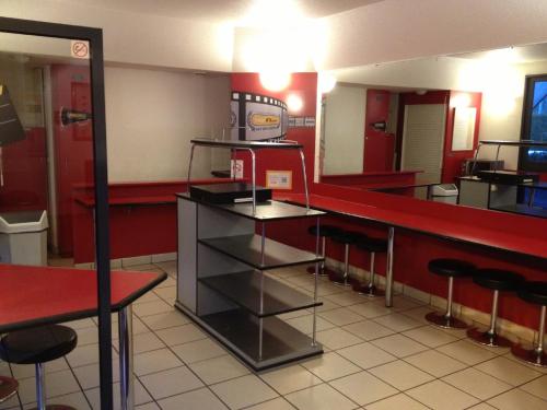 Saint-NabordにあるhotelF1 Remiremont Saint Nabordの赤い壁と椅子のレストランのバー
