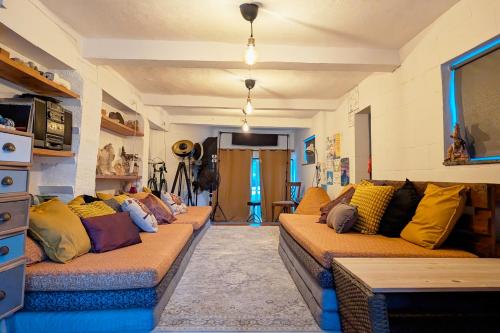 a living room with a long couch with colorful pillows at Loving Strangers Hostel in Madalena