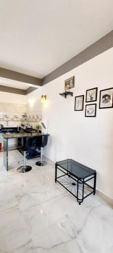 a room with a table and a piano on a white wall at Green House Stay in Mandrem