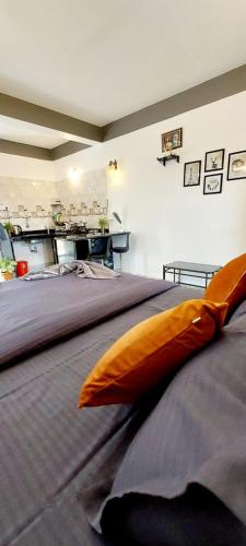 a large bed with an orange pillow on top of it at Green House Stay in Mandrem
