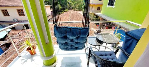 a porch with chairs and a hammock on a balcony at Green House Stay in Mandrem