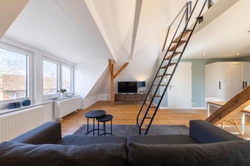 Ferienwohnung Strom ahoi - premium - modern - inkl Stellplatz - 200m zum Alten Strom - Wasserblick في فارنمونده: غرفة معيشة بها درج وأريكة