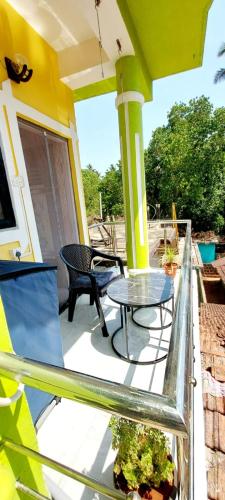 a patio with a table and chairs on a porch at Green House Stay in Mandrem