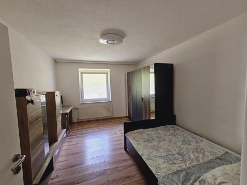 a bedroom with a bed and a dresser and a window at Urlaub mit Bergblick - Ferienhaus in Bad Bleiberg in Bad Bleiberg