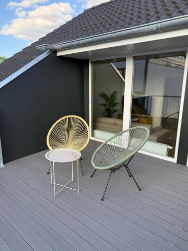 two chairs and a table on a deck at 3-Zimmer-Wohnung in Hamburg am Flughafen in Hamburg