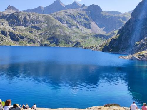des gens debout sur la rive d'un lac de montagne dans l'établissement chalet rural, à Bielle