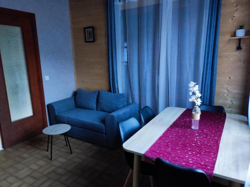 un salon avec une table et un canapé bleu dans l'établissement chalet rural, à Bielle