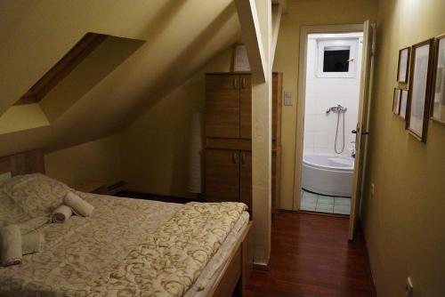 een slaapkamer met een bed en een badkamer met een bad bij Ugostiteljski objekat KARIBO in Sombor