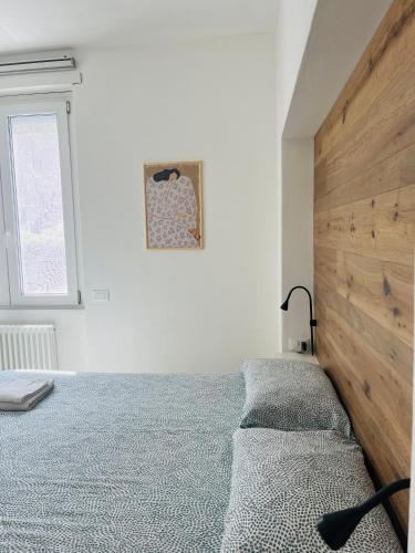a bedroom with a bed with a wooden headboard at Casa Teresa in Riva del Garda
