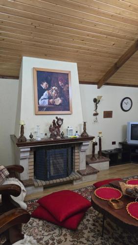 a living room with a fireplace and a painting on the wall at Eni's Villa in Lezhë