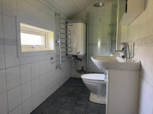 ein Badezimmer mit Toilette und Waschbecken und einem Fenster in der Unterkunft Kustidyll med havsutsikt in Hyppeln