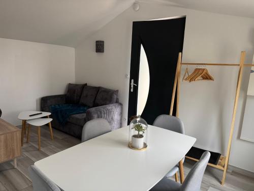 un salon avec une table blanche et un canapé dans l'établissement Maisonnette indépendante, à Chaumont