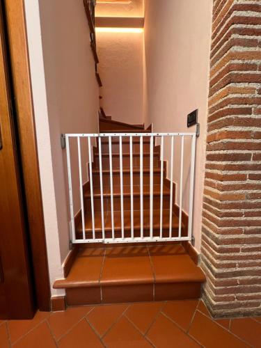 a staircase with a white railing next to a brick wall at La Casa Di Emma in Lucca