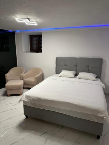 a bedroom with a large bed and two chairs at Luxury Old Town Rab Studio Apartments in Rab