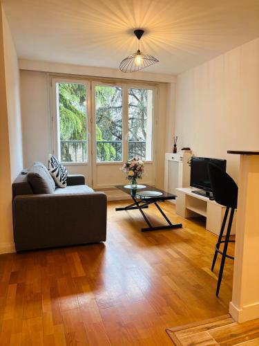 un salon avec un canapé et une table dans l'établissement Lovely appartement, à Paris