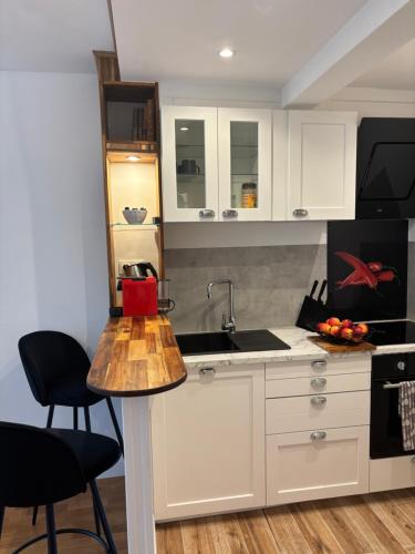 une cuisine avec des armoires blanches et un évier dans l'établissement Lovely appartement, à Paris