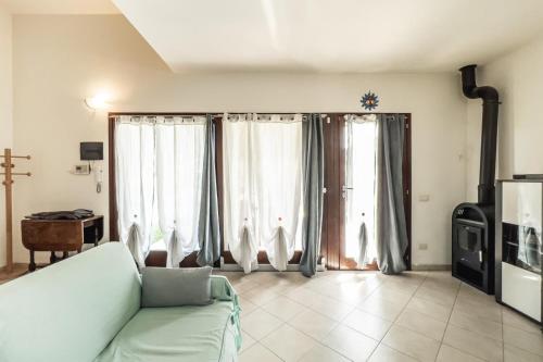 a living room with a couch and some windows at Villa Cala Sinzias in Castiadas