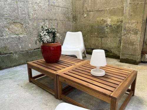 une table basse en bois avec un pot de fleurs dessus dans l'établissement Loft avec Parking au centre historique de Saintes, à Saintes