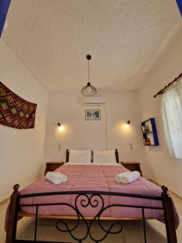 a bedroom with a bed with a purple blanket at Stefanos Garden in Arménoi