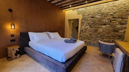 a large bed in a room with a stone wall at La Torre sulla via Francigena in Gambassi Terme