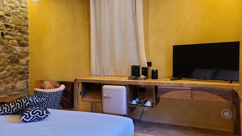 a room with a desk with a tv and a bed at La Torre sulla via Francigena in Gambassi Terme