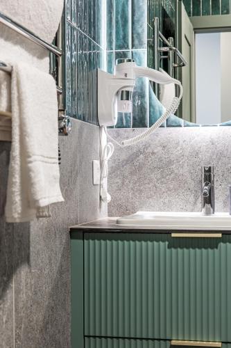 a bathroom with a sink and a mirror and towels at Baliò Villa in Palanga